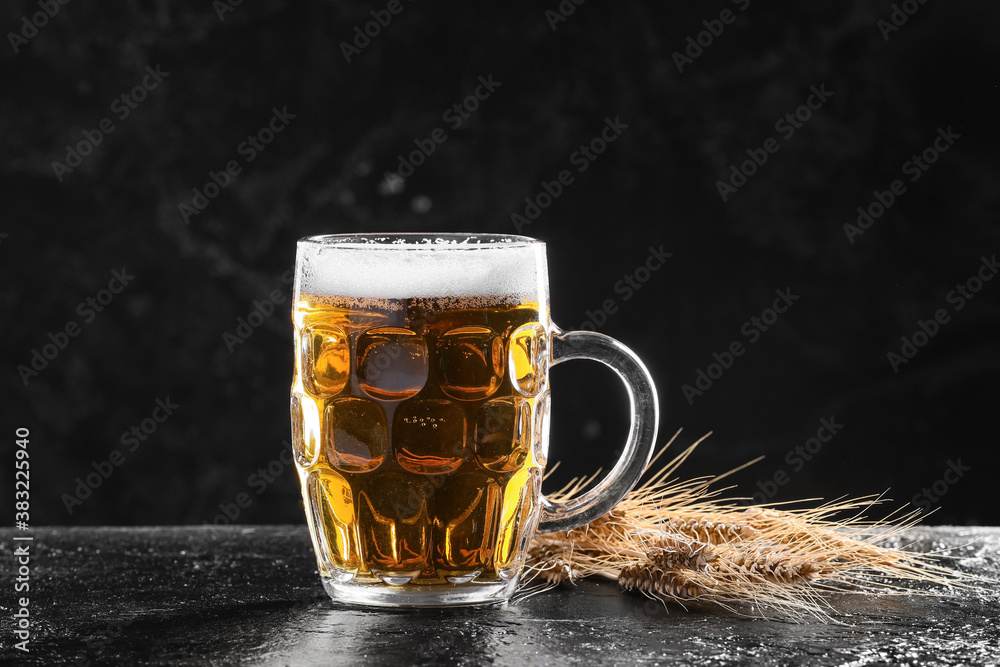 Mug of fresh beer on dark background