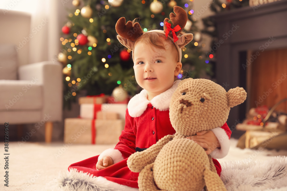 Cute little baby in Christmas costume at home