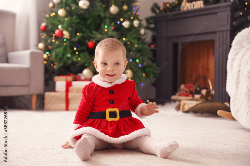 Cute little baby in Santa costume at home on Christmas eve