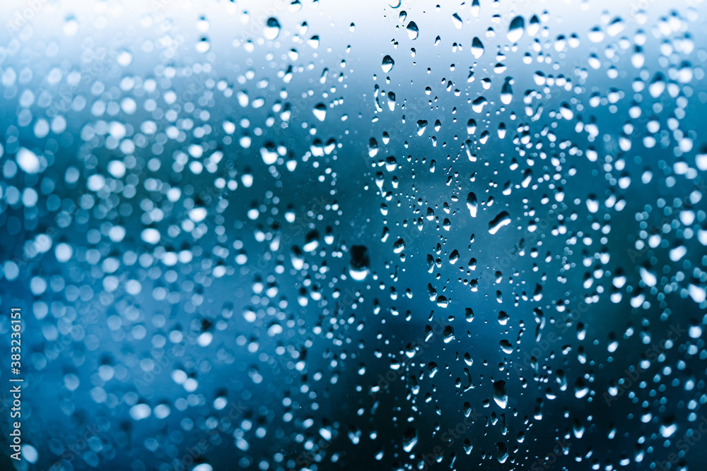 Rainy days. Heavy rain falling on window surface. Rain water drops falling down on the window glass.