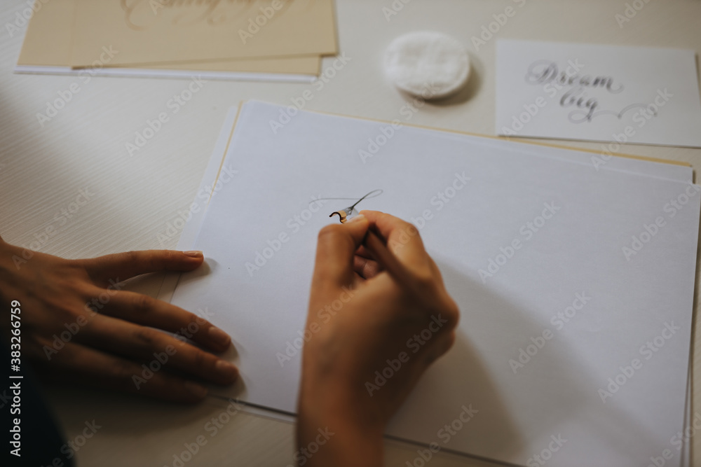 Close-up photo of female person writing note with old-fashioned fountain pen.