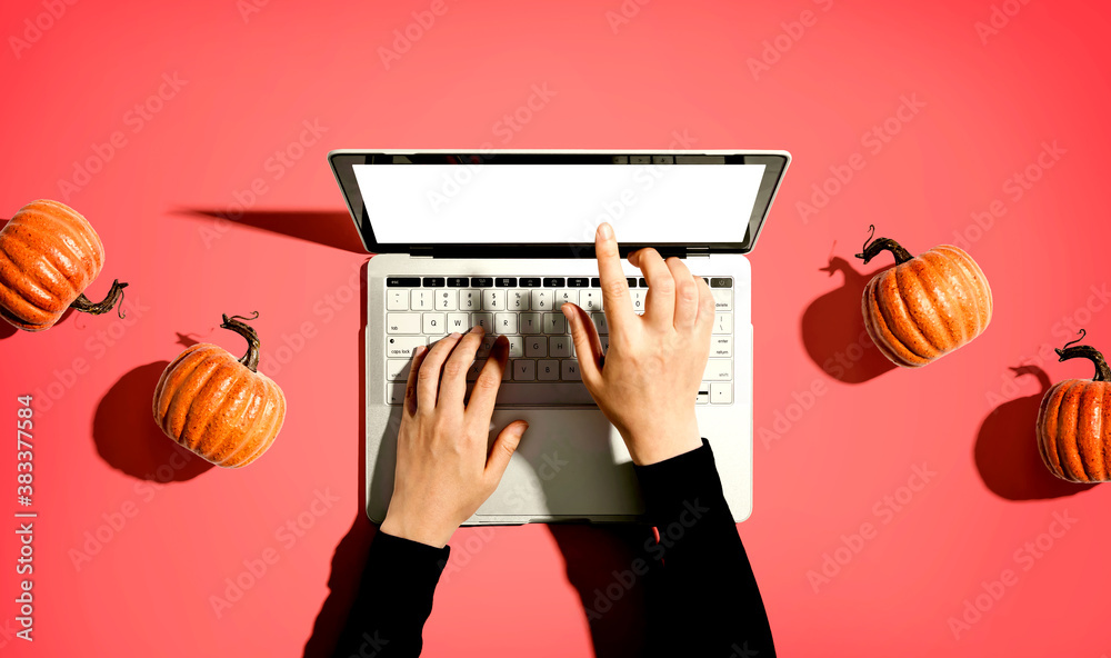 Autumn pumpkins with person using a laptop computer from above