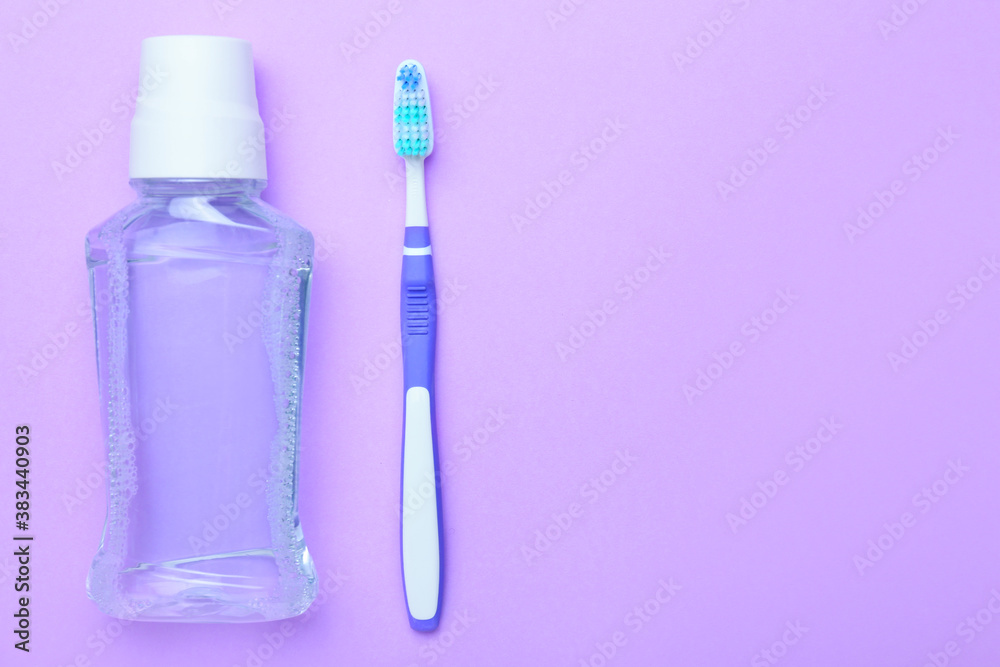 Tooth brush and mouth rinse on color background