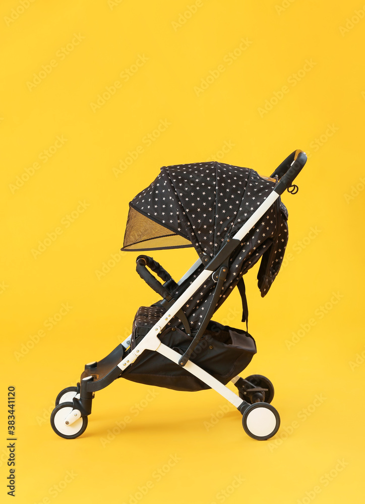 Modern baby stroller on color background