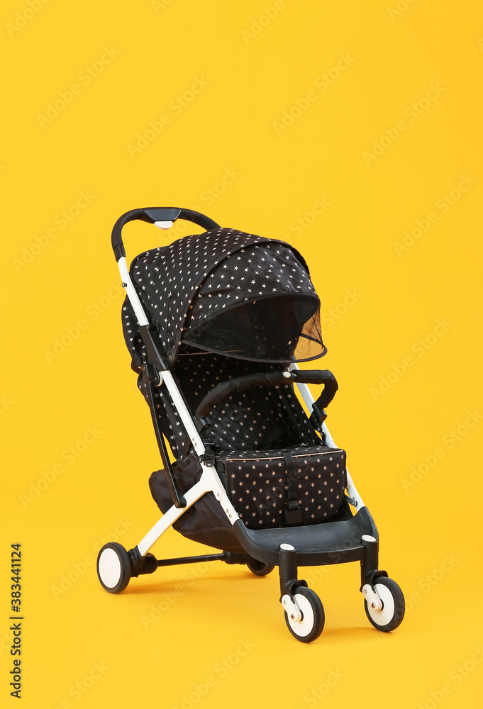 Modern baby stroller on color background