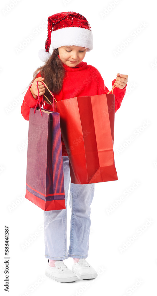 Cute little girl in Santa hat and with shopping bags on white background