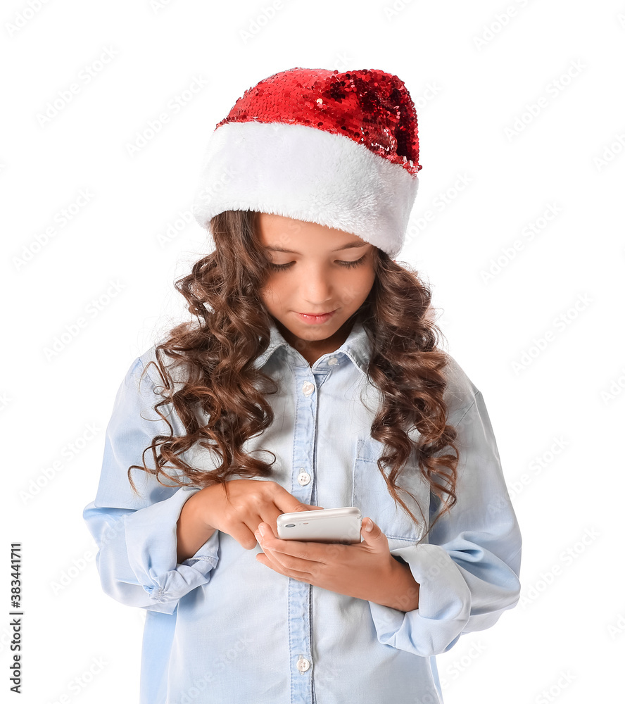 Cute little girl in Santa hat and with mobile phone on white background