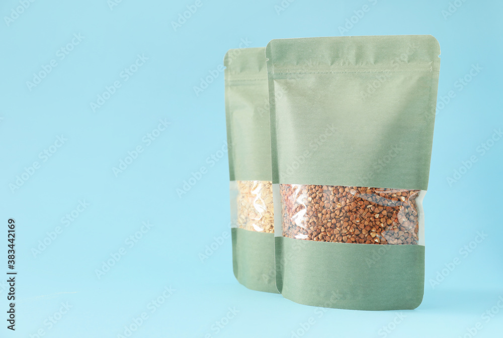 Bags with different groats on color background