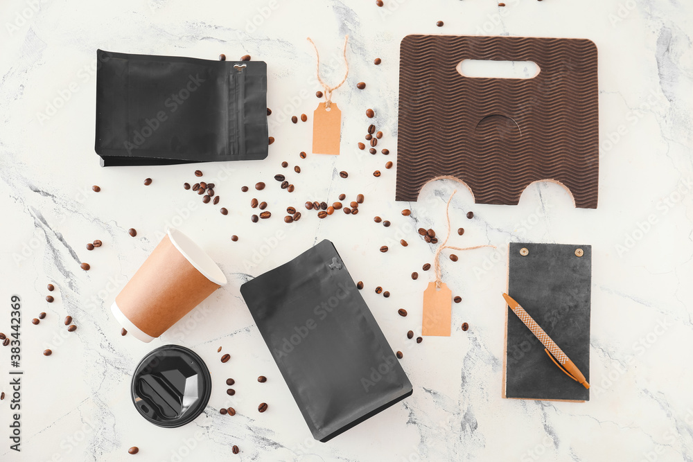 Blank bags with coffee beans and cup on white background