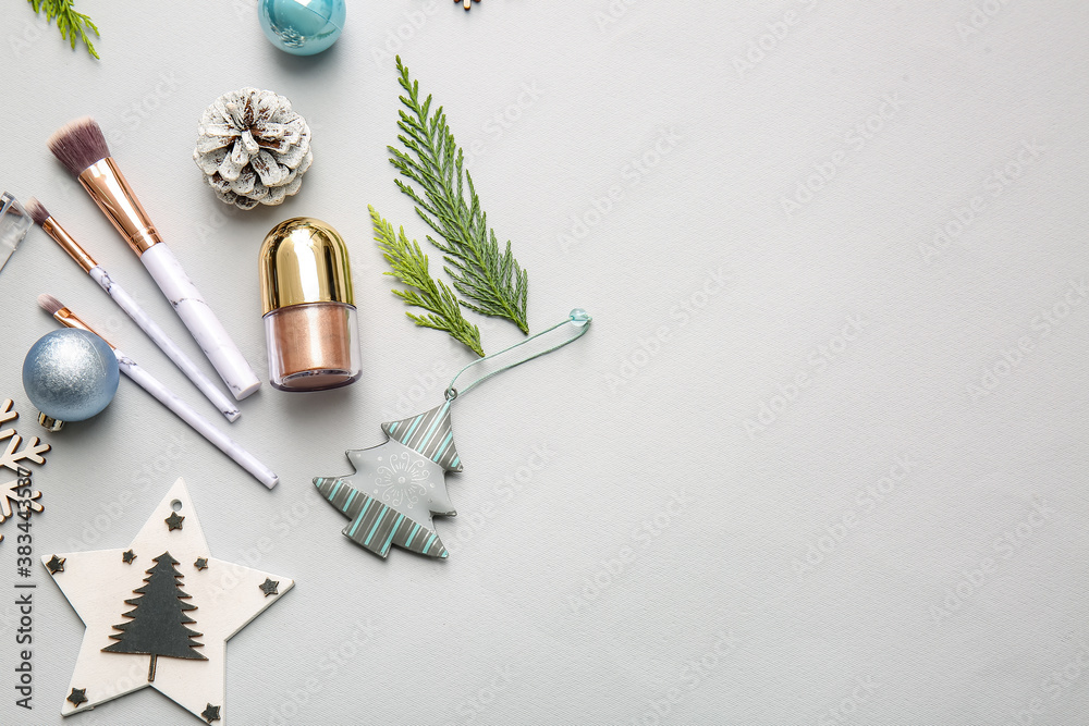 Christmas composition with cosmetics on light background