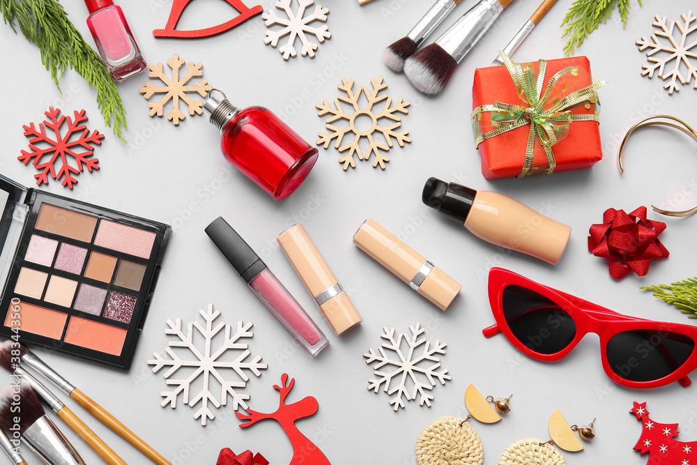 Christmas composition with cosmetics on light background