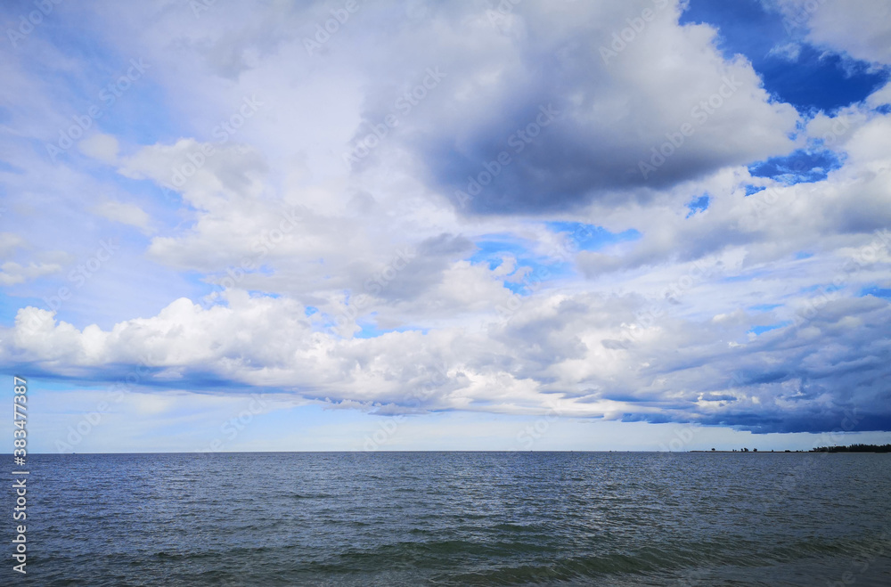 Calm sea on a cloud blue sky day