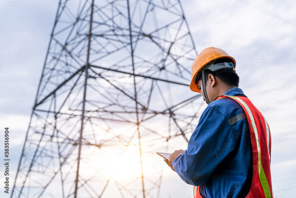 Engineering wear safety clothes working on High-voltage tower, Check the information on taplet..