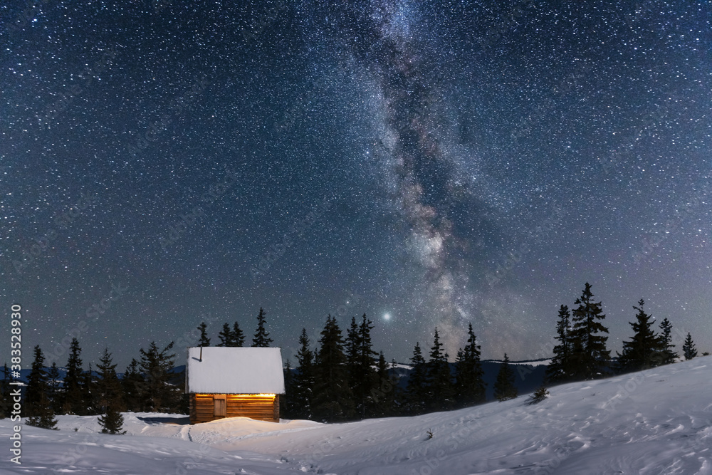 雪山木屋的奇妙冬季景观。银河和雪的星空