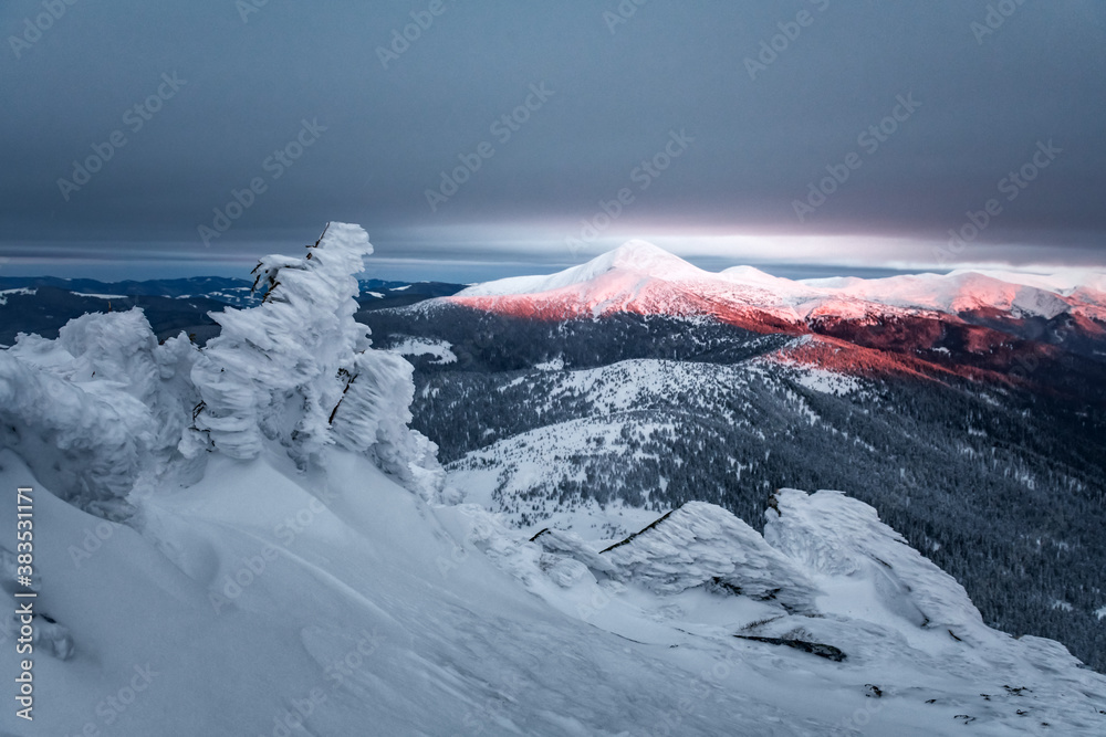 Fantastic orange winter landscape in snowy mountains glowing by sunlight. Dramatic wintry scene with