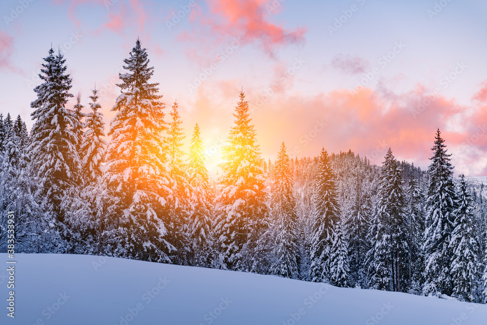 Fantastic orange winter landscape in snowy mountains glowing by sunlight. Dramatic wintry scene with