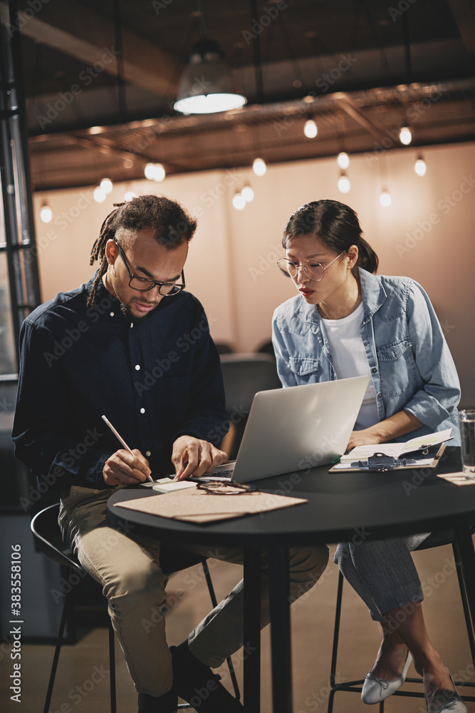 Two diverse young businesspeople working in an office