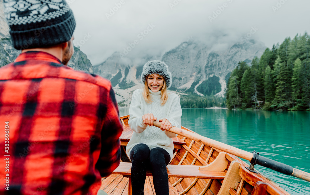 Romantic couple on a boat visiting an alpine lake at Braies Italy. Tourist in love spending loving m