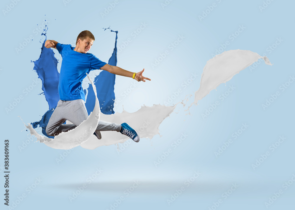 young male dancer jumping with splash of paint