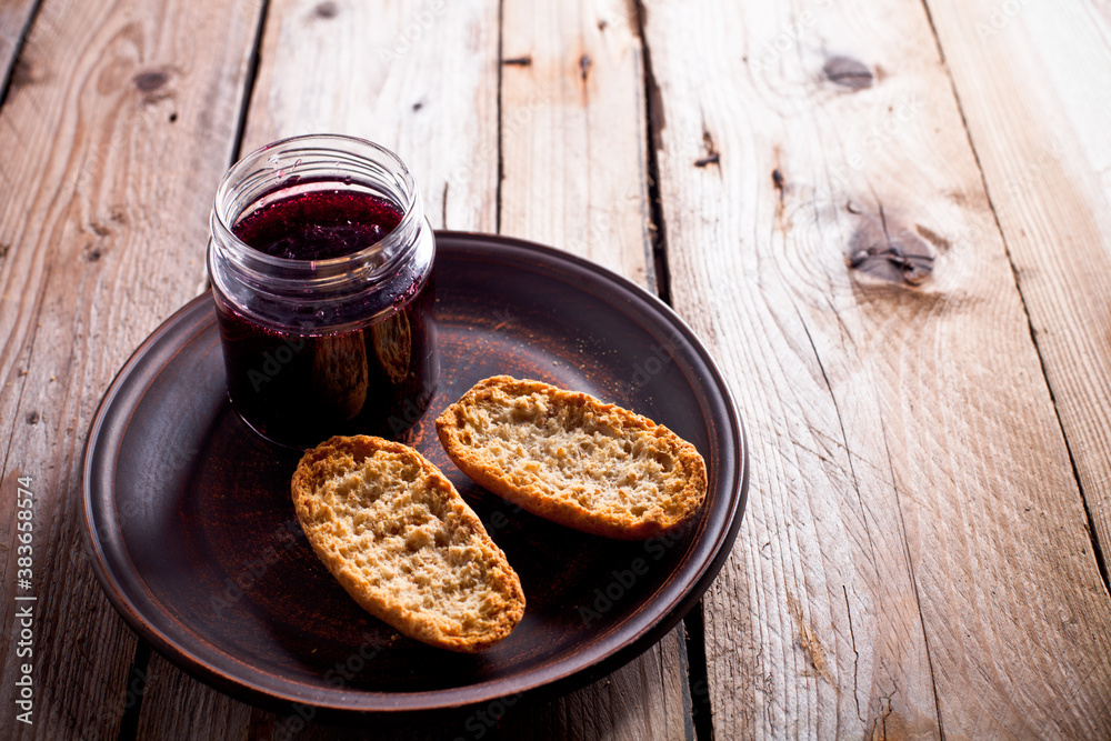 black currant jam in glass jar and crackers