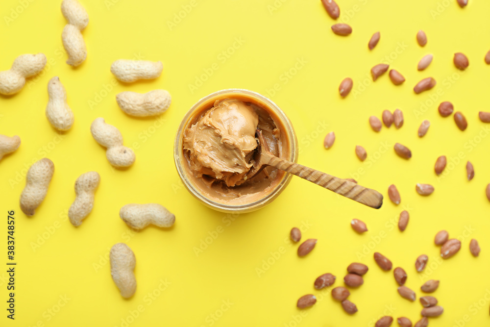 Composition with tasty peanut butter on color background