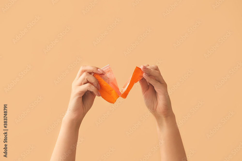 Female hands tearing plastic cup on color background. Ecology concept