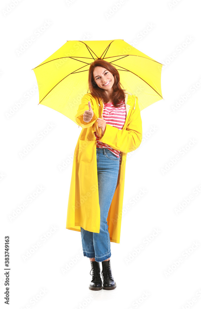 Beautiful young woman in raincoat and with umbrella on white background