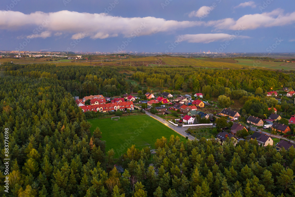 Aerial landscape of the soccer field by the forest at sunset