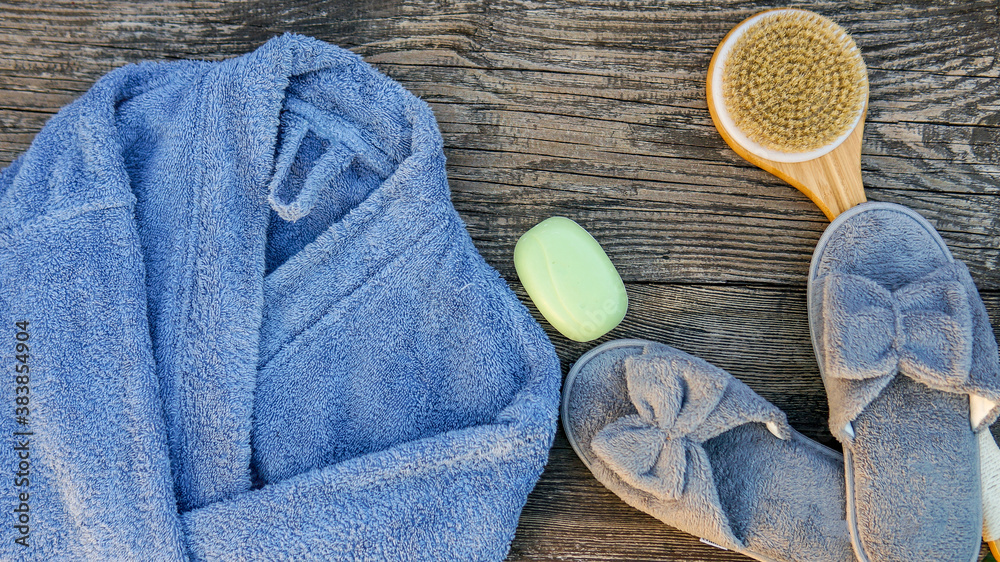 Spa day concept. Spa and wellness setting with bathrobe, brush, soap with lavender scent, slippers