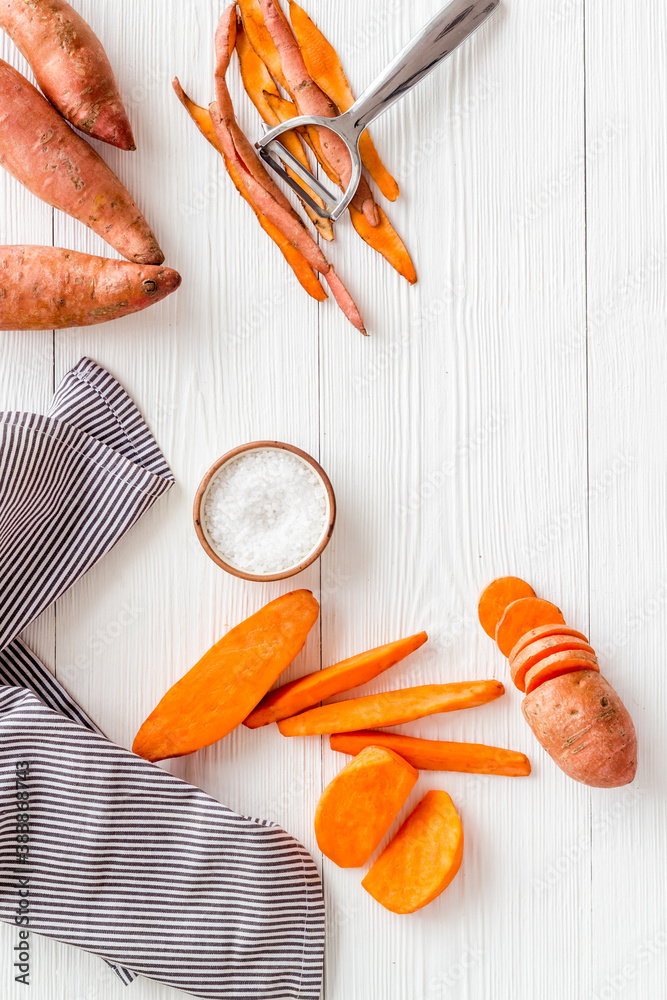 Overhead view of sweet potato sliced on kitchen board. Top view