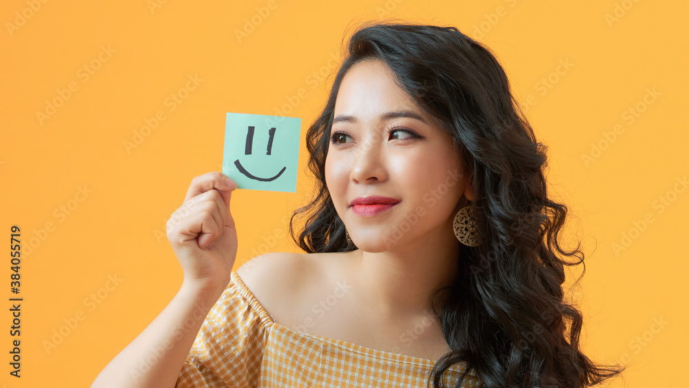 Close-up portrait of sweet girl demonstrating sticker emotion isolated over bright yellow color back