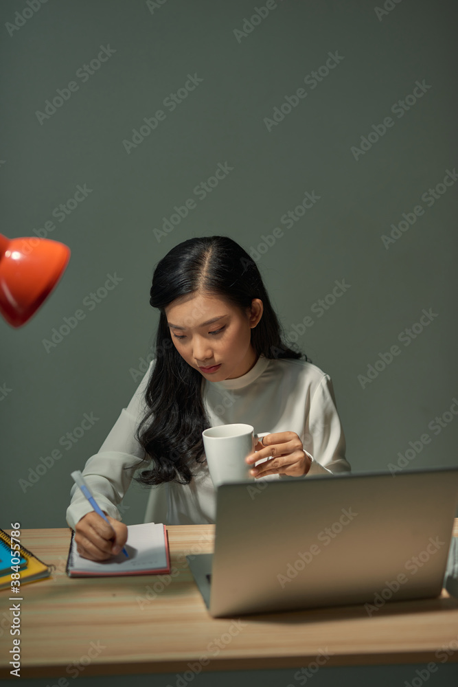 Smiling Asian girl having online classes at home