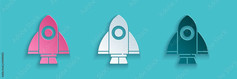 Paper cut Rocket ship icon isolated on blue background. Space travel. Paper art style. Vector.