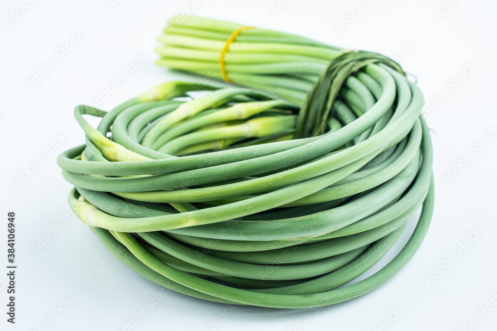 Handful of fresh garlic moss on white background