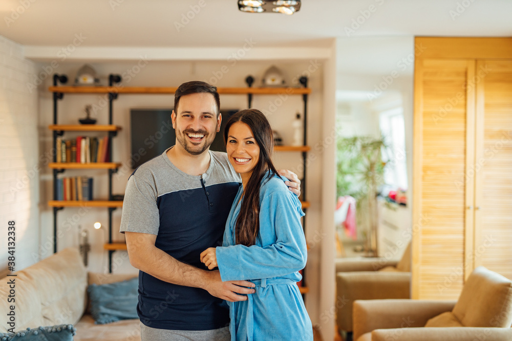 Home portrait of a happy couple in pajamas and bathrobe.