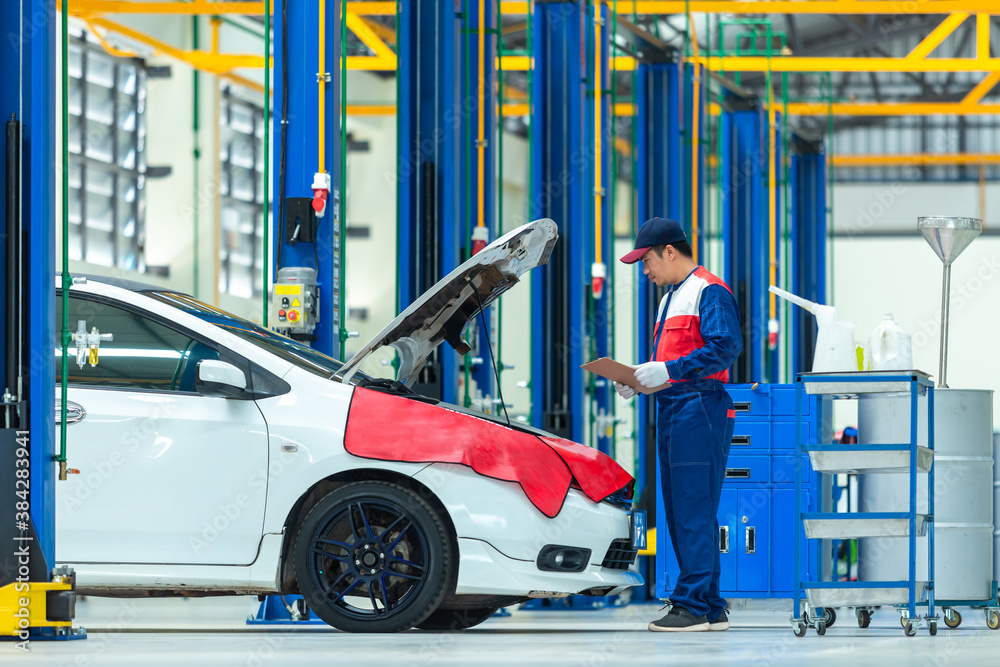 Auto mechanic working in car auto repair service center.