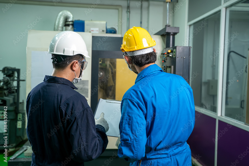 Industrial factory employee working and checking near electric meters panel of a control room in ind