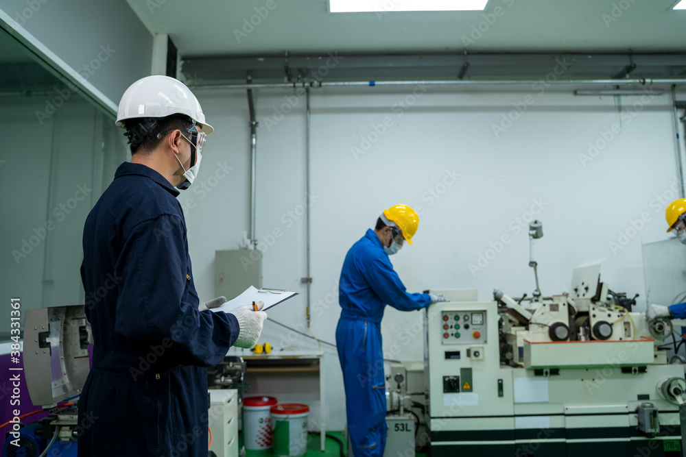 Industrial factory employee working and checking near electric meters panel of a control room in ind