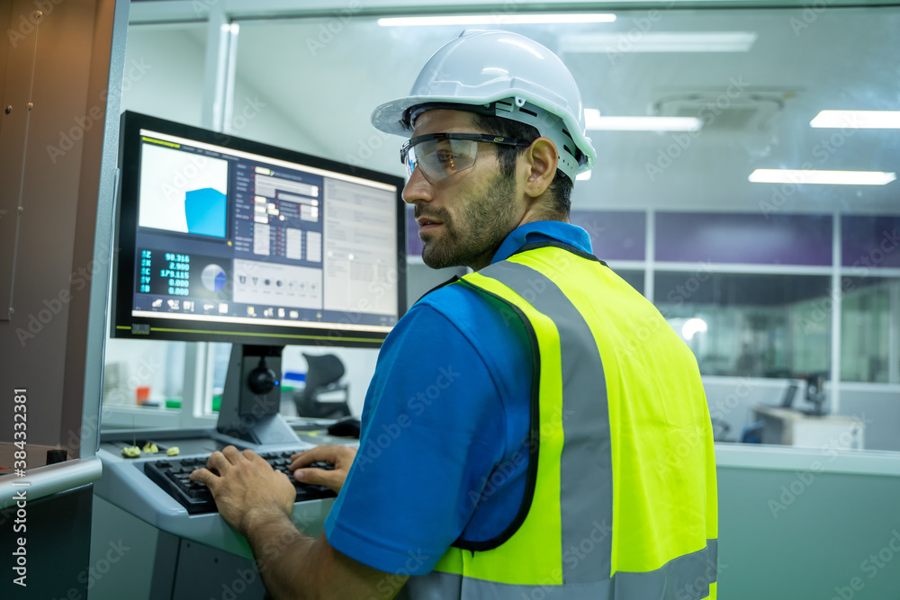 Engineer mechanic use laptop working and checking machine in a large industrial factory.