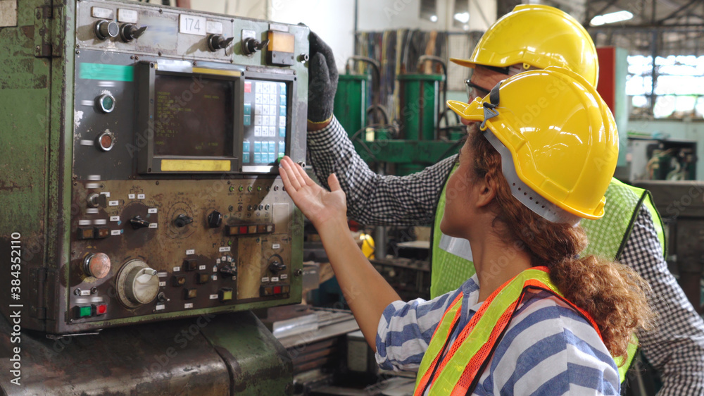 Group of factory workers using machine equipment in factory workshop . Industry and engineering conc