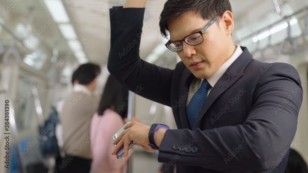 Businessman using mobile phone on public train . Urban city lifestyle commuting concept .