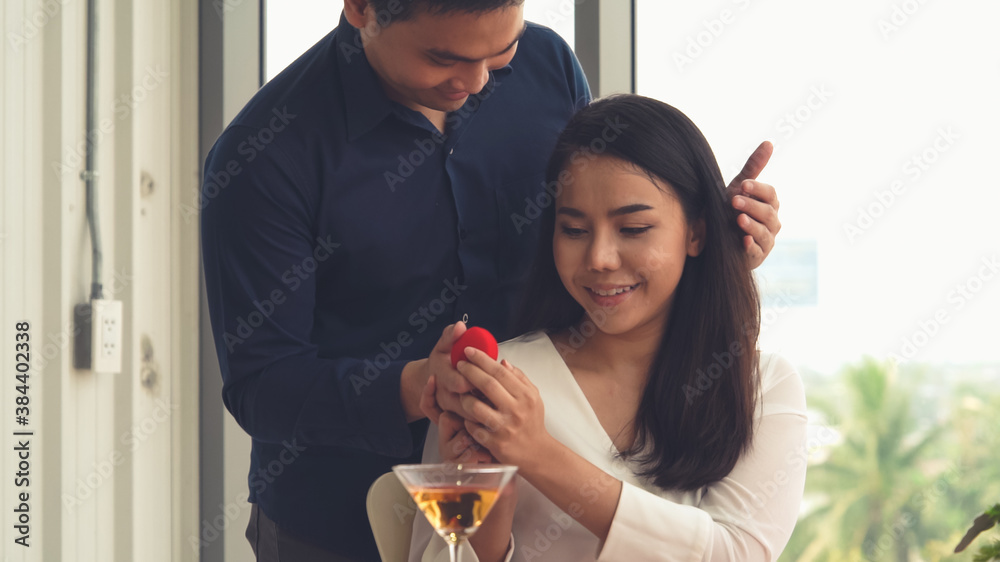 Romantic couple giving gift to lover at restaurant . Happy couple lifestyle .