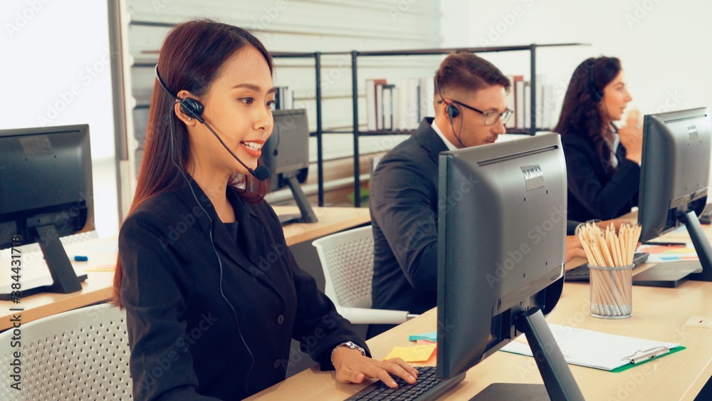 Business people wearing headset working in office to support remote customer or colleague. Call cent