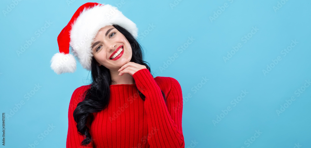 Young woman with Santa hat thoughtful pose on a blue background