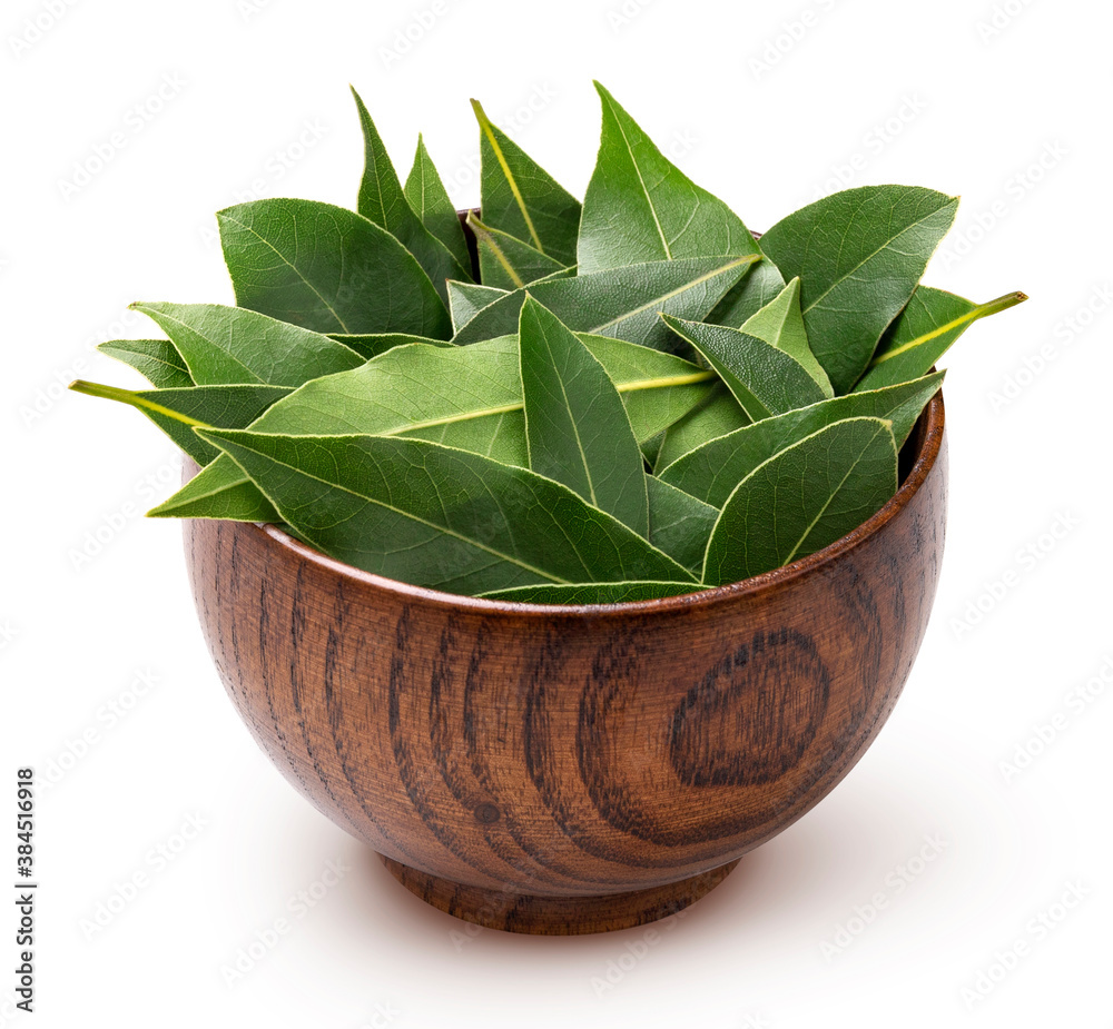 Bay leaves in wooden bowl isolated on white background