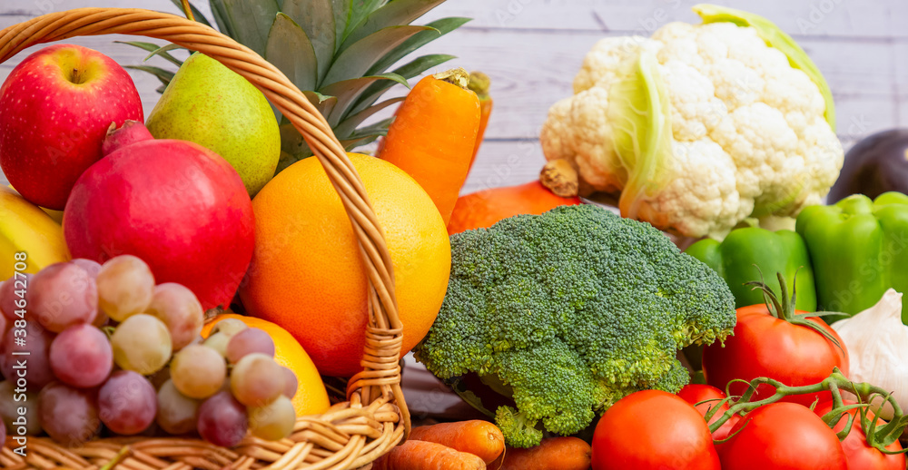 Group vegetables and Fruits Apples, grapes, oranges, and bananas in the wooden basket with carrots, 