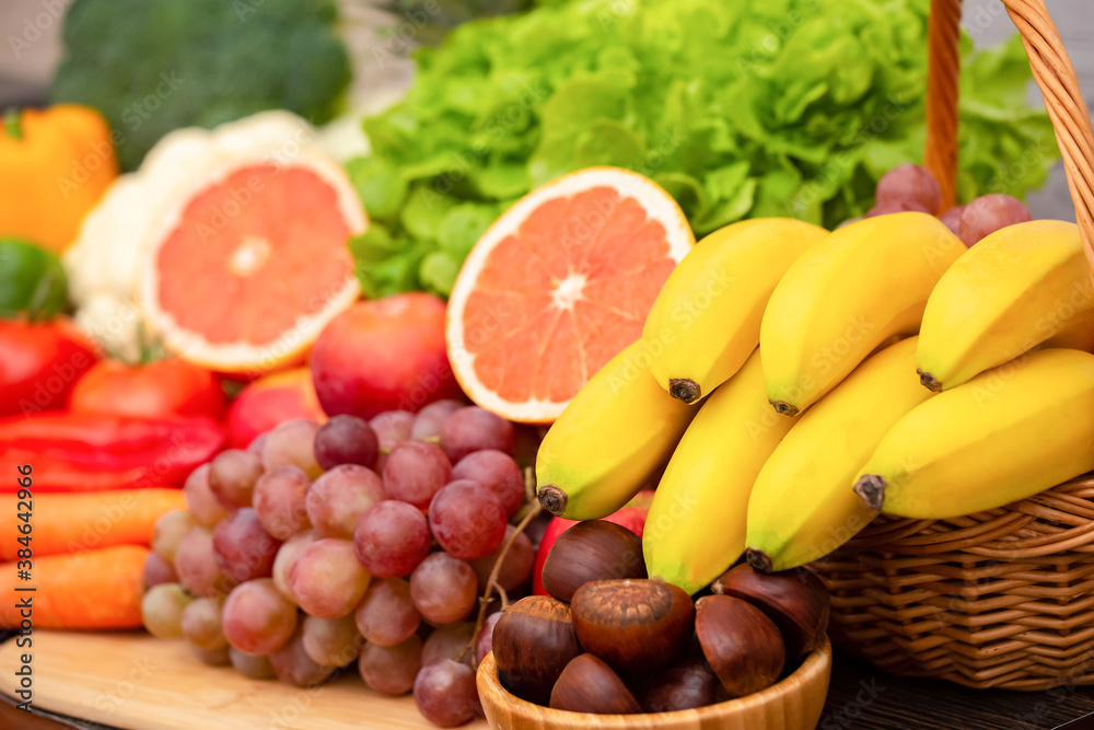 Group vegetables and Fruits Apples, grapes, oranges, and bananas in the wooden basket with carrots, 