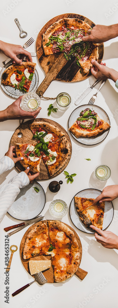 Pizza party for friends or family. Flat-lay of various pizzas, drinks and peoples hands over white t