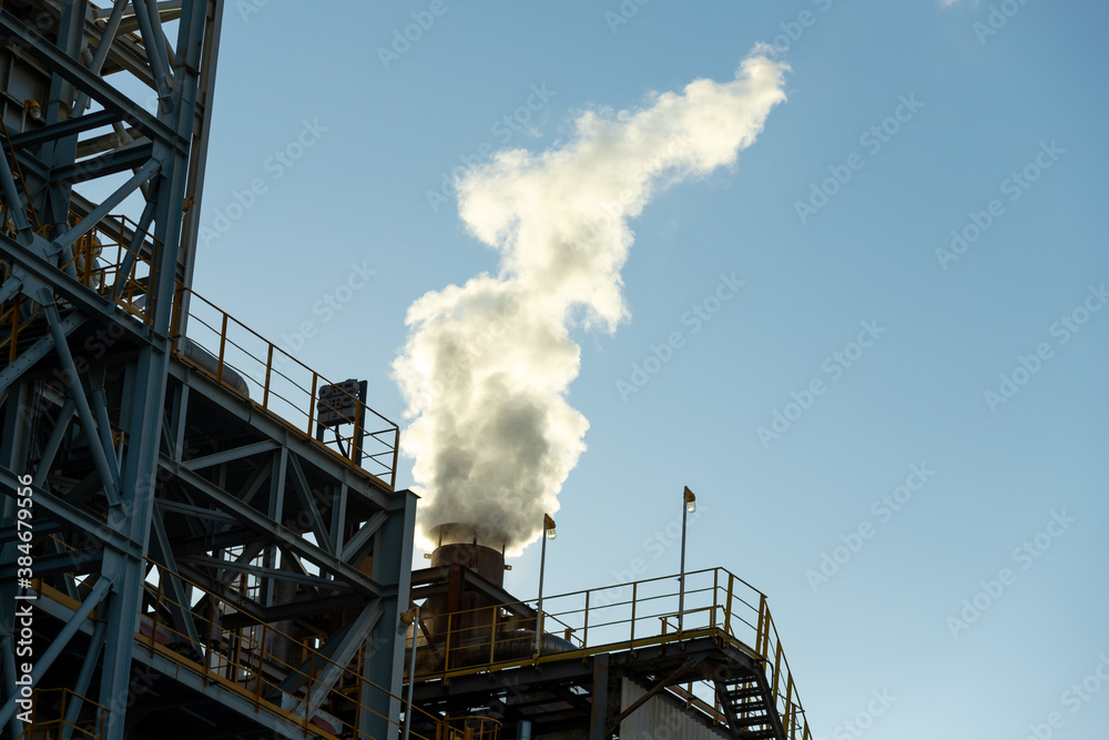 Close up steam outlet pipe of oil and gas refinery plant form industry zone with sunrise and cloudy 