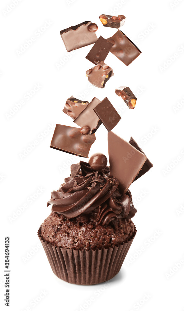 Tasty cupcake and falling sweet chocolate on white background